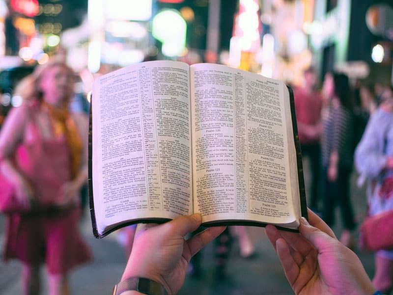 hands holding an open Bible